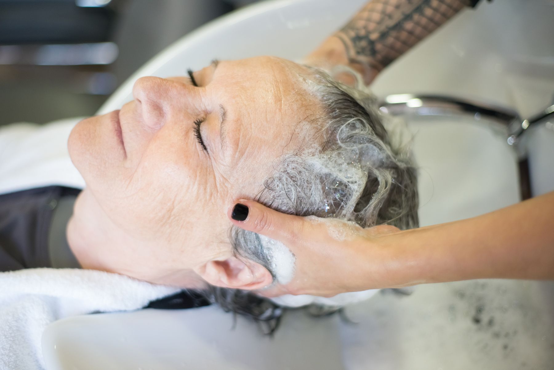Client relaxing while her hair is shampooed